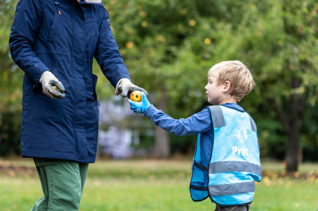 Student hands an adult an apple