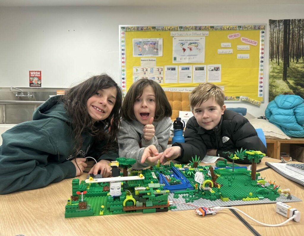 students with lego sitting at desk