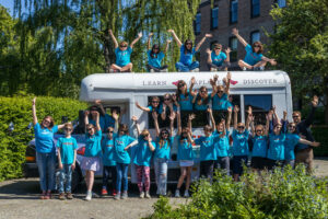 The entire fifth grade class poses around, in, and even on the school bus!
