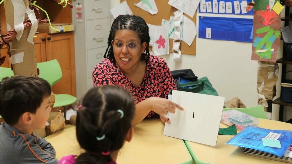 Learning specialist shows students a whiteboard with an i