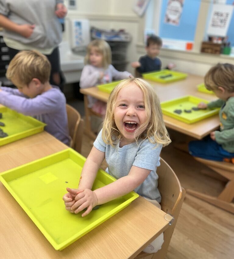 Student smiles while molding clay